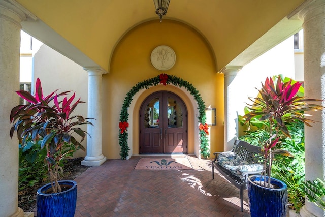 view of exterior entry with stucco siding and french doors