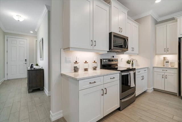 kitchen featuring appliances with stainless steel finishes, backsplash, ornamental molding, and white cabinets