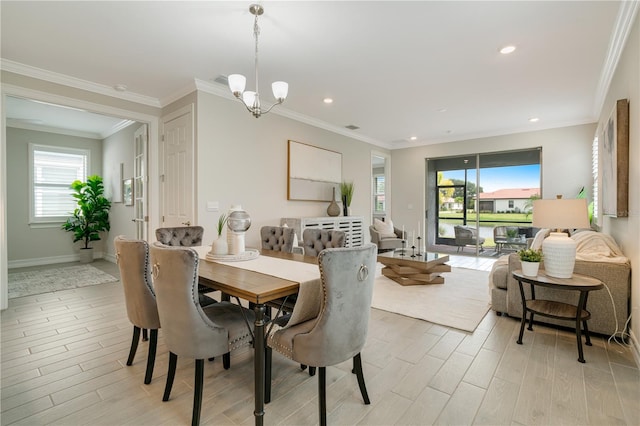 dining space featuring ornamental molding, light hardwood / wood-style flooring, and a chandelier