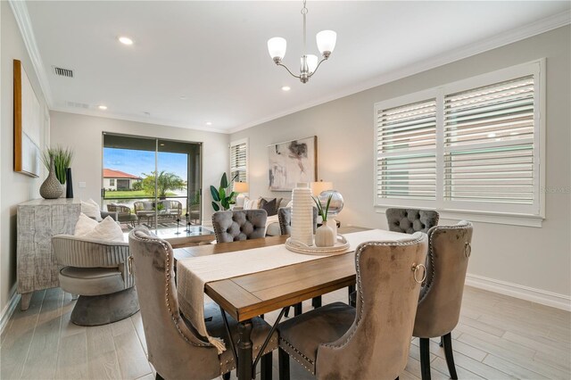 dining area with ornamental molding, light hardwood / wood-style floors, and a notable chandelier