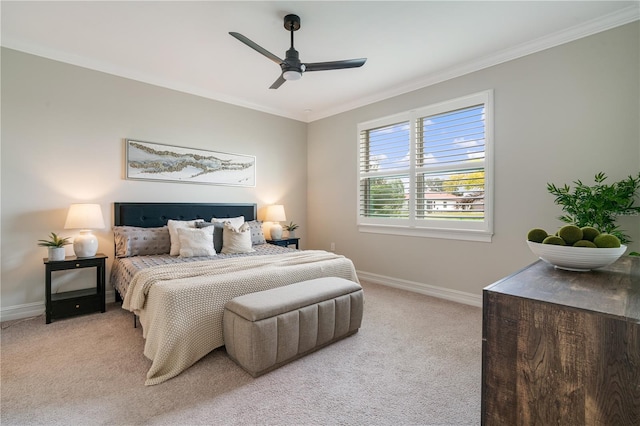 carpeted bedroom featuring ceiling fan and crown molding