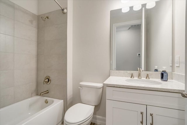 full bathroom featuring tiled shower / bath, vanity, and toilet