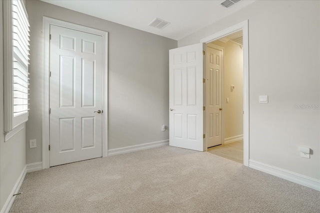 unfurnished bedroom featuring light colored carpet