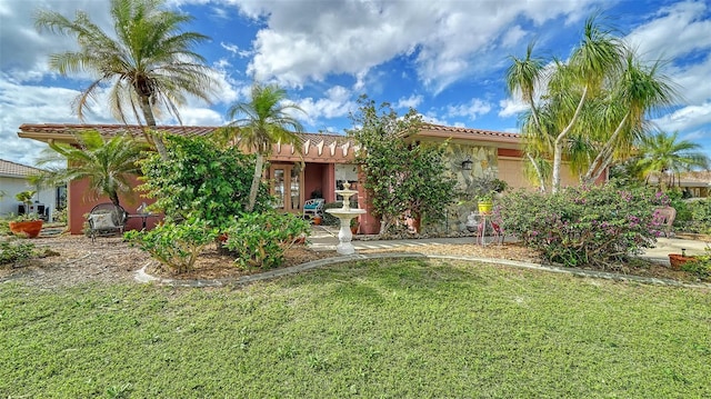 view of front of house featuring stucco siding, french doors, a front lawn, and a tile roof