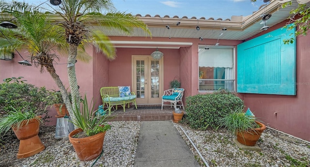 view of exterior entry featuring french doors and a porch