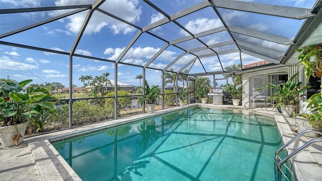 view of swimming pool featuring a patio area and glass enclosure