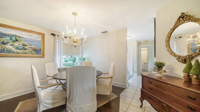 dining area with a chandelier, visible vents, and baseboards