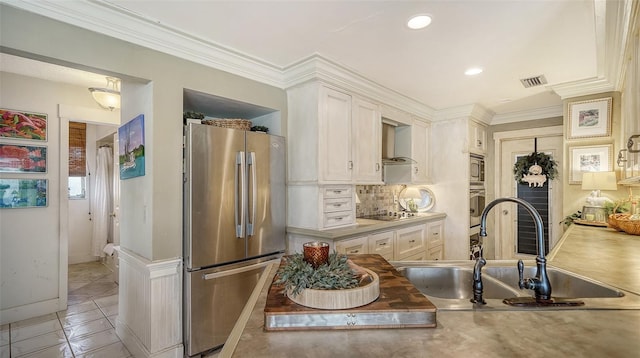 kitchen featuring white cabinets, backsplash, sink, wall chimney exhaust hood, and stainless steel appliances