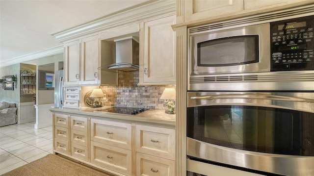 kitchen with wall chimney range hood, stainless steel appliances, backsplash, ornamental molding, and light tile patterned floors