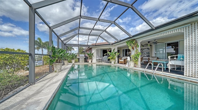 view of swimming pool with a patio, a lanai, and ceiling fan