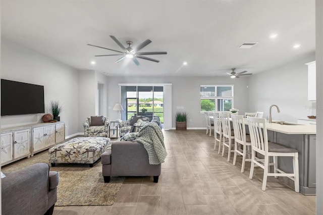 living room featuring ceiling fan and sink