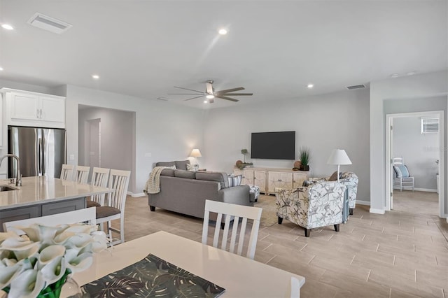 living room featuring ceiling fan and light hardwood / wood-style flooring