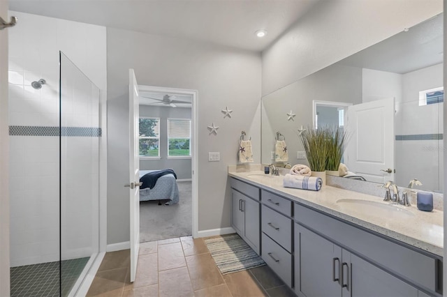 bathroom with ceiling fan, vanity, a tile shower, and tile patterned floors