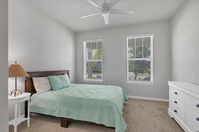 carpeted bedroom featuring multiple windows and ceiling fan