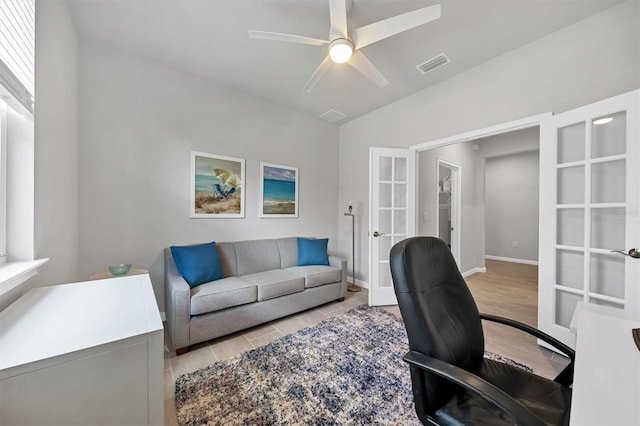 office space featuring light hardwood / wood-style floors, ceiling fan, and french doors