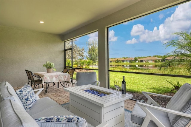 sunroom featuring a water view