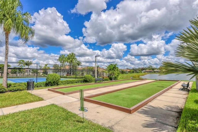 view of property's community featuring a yard, a water view, and tennis court