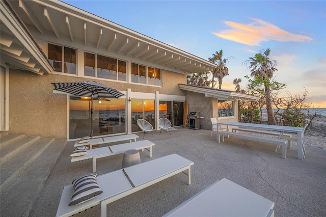 patio terrace at dusk featuring grilling area