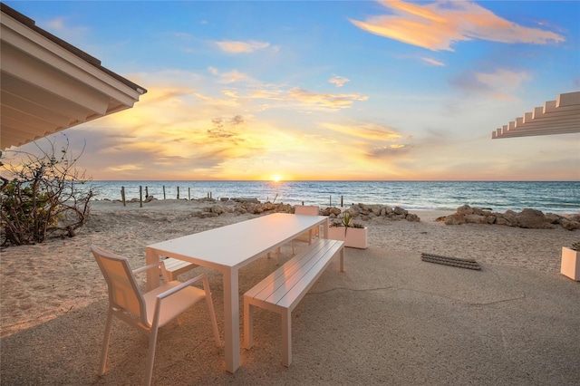 exterior space with a patio area, a water view, and a view of the beach