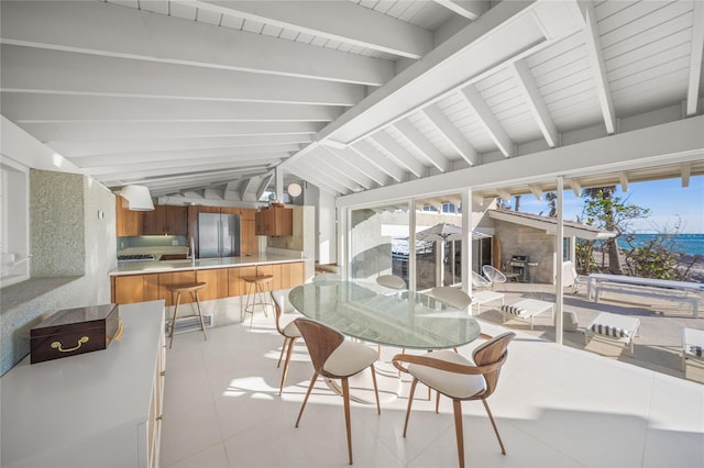 sunroom / solarium featuring lofted ceiling with beams