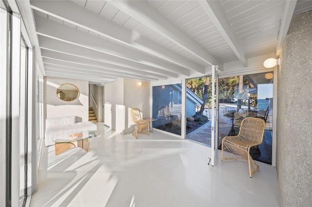 sunroom / solarium featuring beamed ceiling