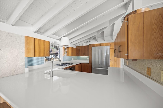 kitchen with sink, built in refrigerator, vaulted ceiling with beams, decorative backsplash, and kitchen peninsula