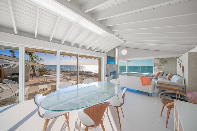 sunroom / solarium with a water view and lofted ceiling with beams