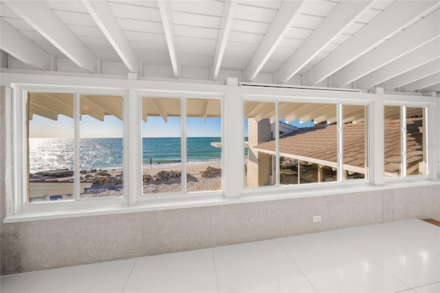 unfurnished sunroom with a water view and a view of the beach