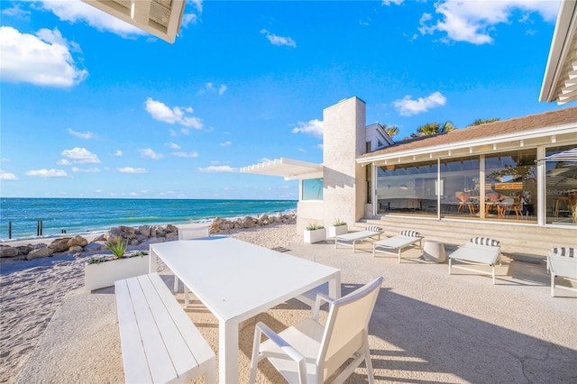 view of patio with a water view and a view of the beach