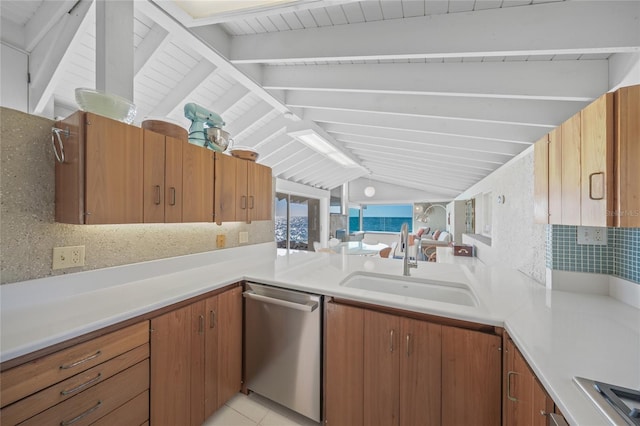 kitchen featuring stainless steel dishwasher, tasteful backsplash, sink, and vaulted ceiling