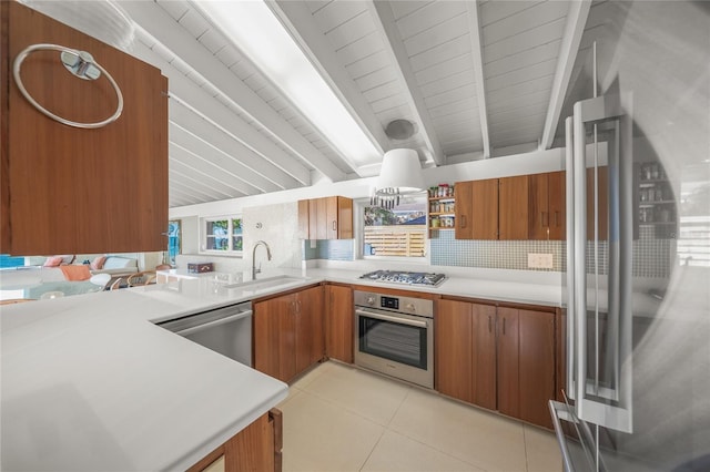 kitchen with kitchen peninsula, tasteful backsplash, stainless steel appliances, sink, and light tile patterned floors