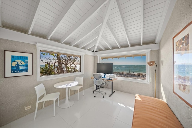 tiled office space featuring lofted ceiling with beams