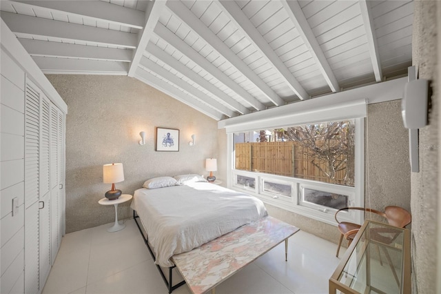 tiled bedroom with vaulted ceiling with beams and a closet