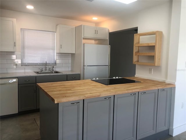 kitchen with gray cabinetry, white appliances, sink, and wooden counters