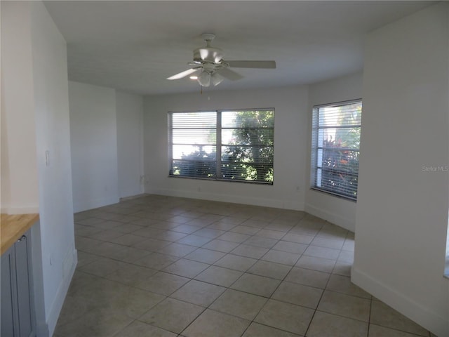 unfurnished room with ceiling fan and light tile patterned floors