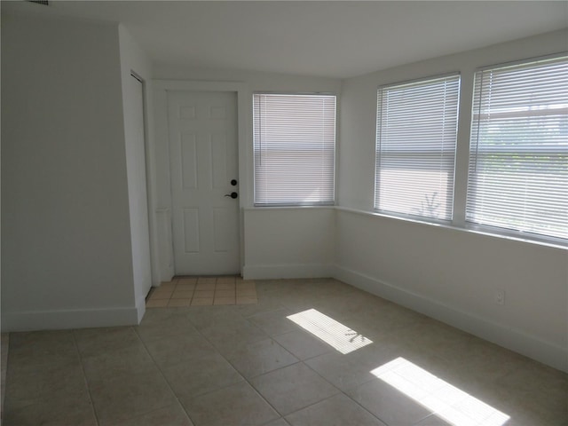 tiled empty room featuring a healthy amount of sunlight