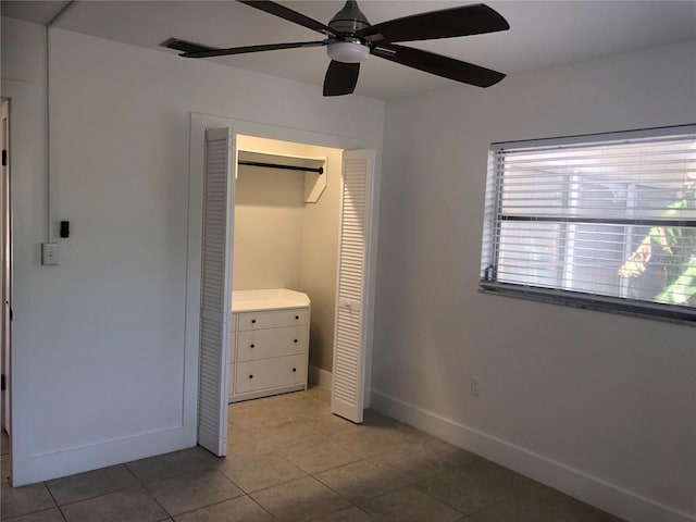 unfurnished bedroom with light tile patterned floors, ceiling fan, and a closet