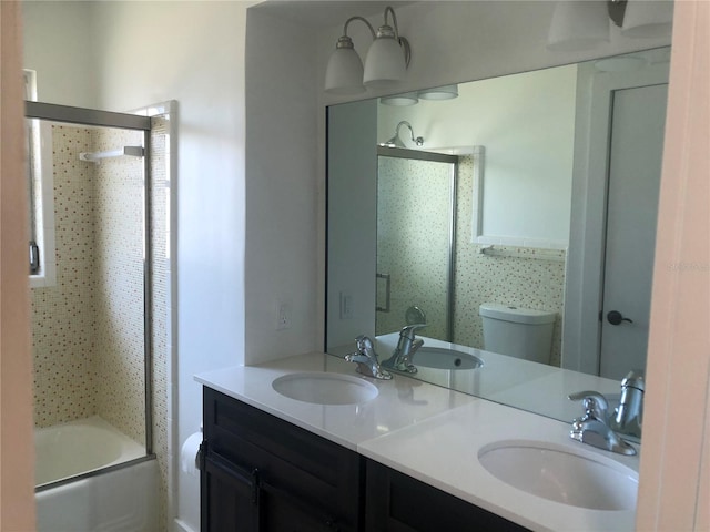 full bathroom featuring enclosed tub / shower combo, vanity, and toilet