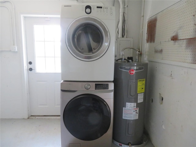 laundry room with water heater and stacked washer / drying machine