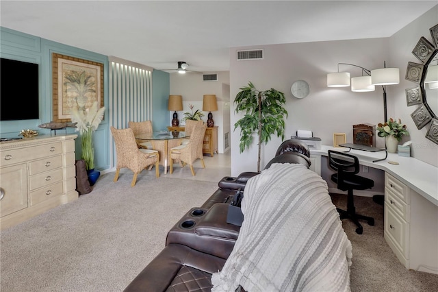 living room featuring light carpet, built in desk, and ceiling fan