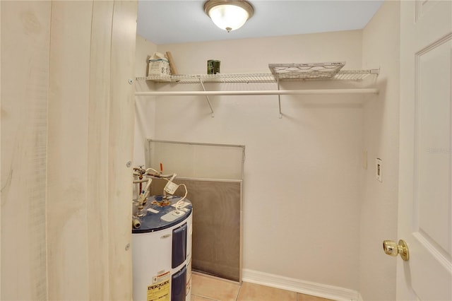 walk in closet with electric water heater and light tile patterned flooring