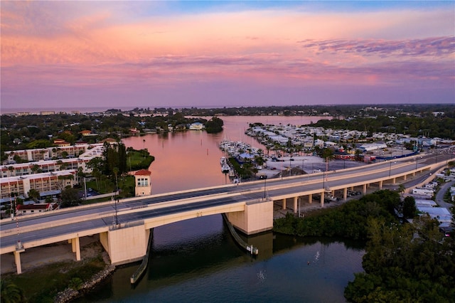 aerial view at dusk featuring a water view