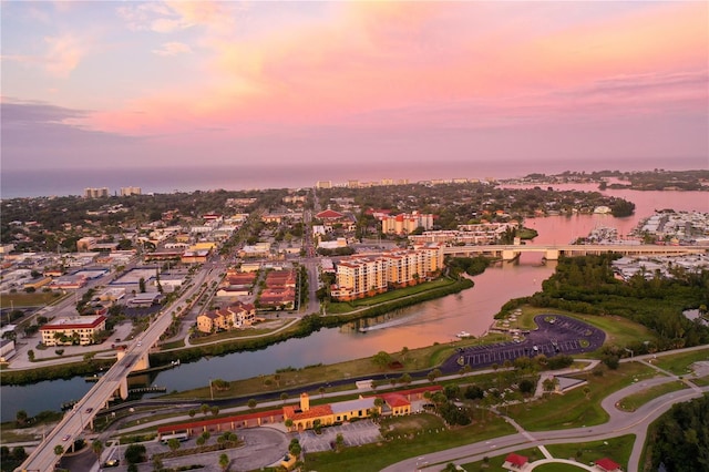 aerial view at dusk featuring a water view