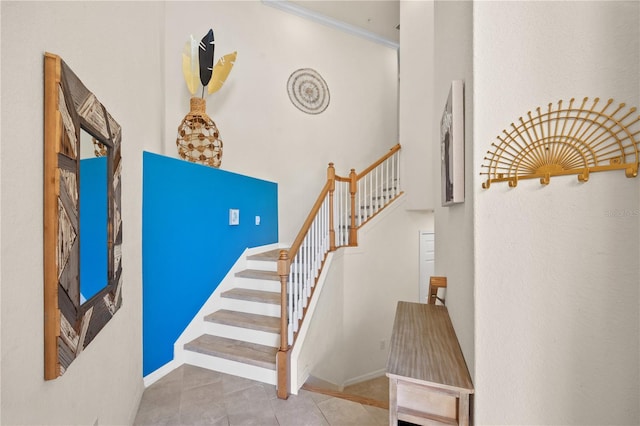 staircase with tile patterned flooring and ornamental molding