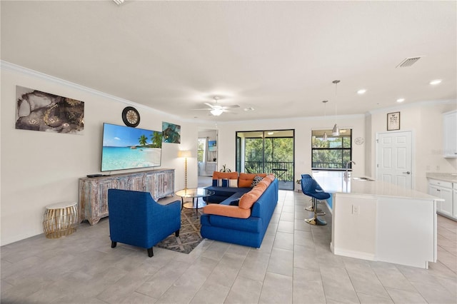 tiled living room with crown molding, sink, and ceiling fan