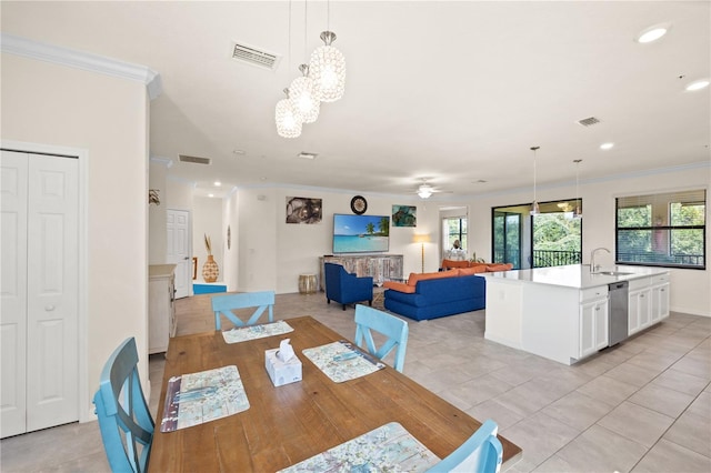 dining space featuring sink, ornamental molding, and light tile patterned flooring