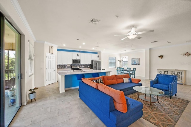 tiled living room with a healthy amount of sunlight, ornamental molding, sink, and ceiling fan