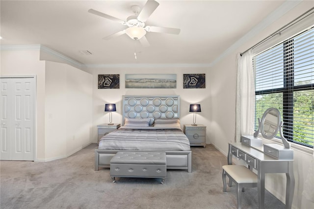 bedroom with ceiling fan, light colored carpet, a closet, and ornamental molding