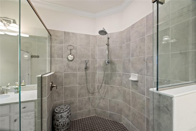 bathroom with a tile shower, ornamental molding, and vanity