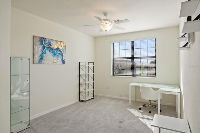 unfurnished office with ceiling fan and light carpet